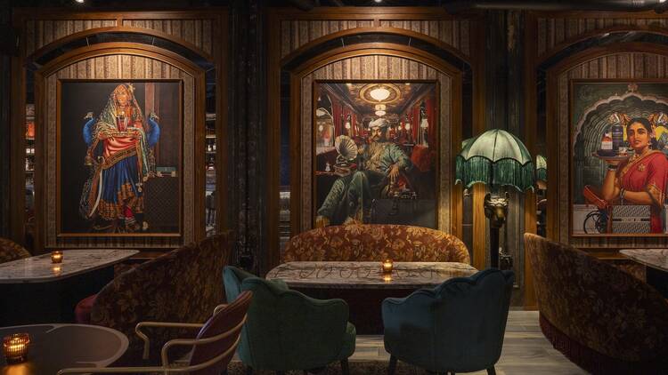 Saaqi bar with plush velvet chairs and grand portraits