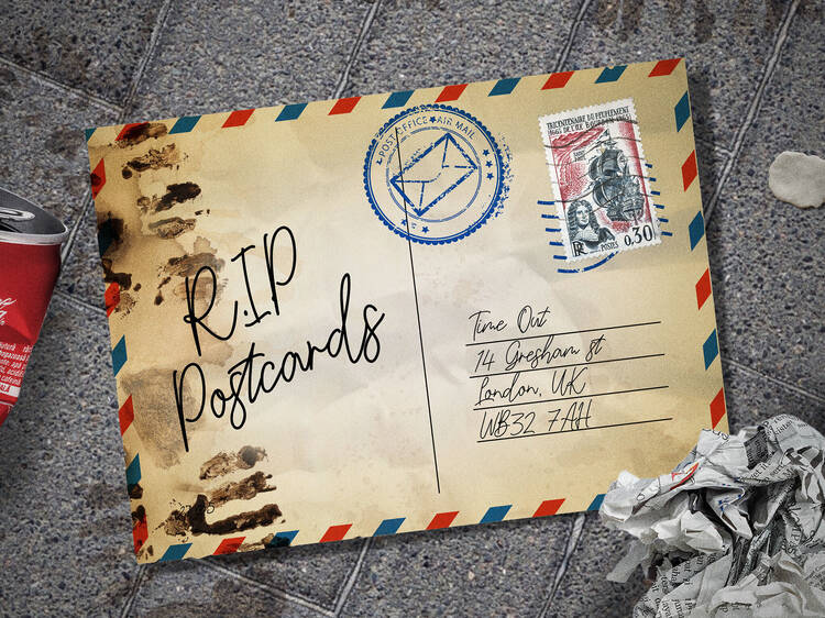A postcard on the ground reading RIP Postcards