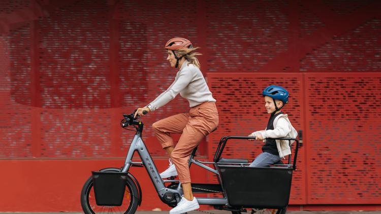 A woman cycling on an eBike with her child