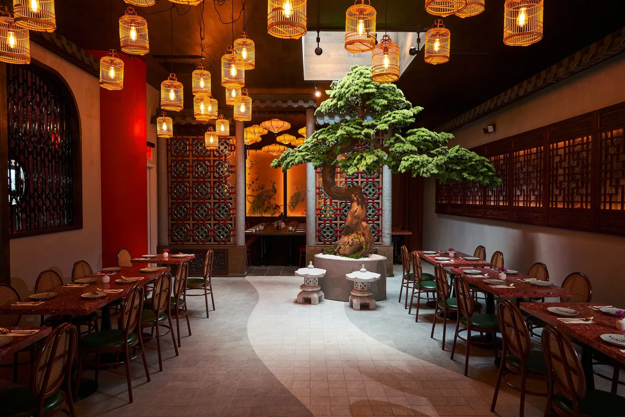 A dining room with birdcage lights and a tree near the rear