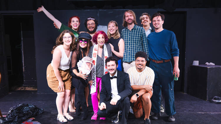 The cast of the trash king posing for a picture on stage