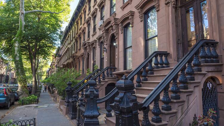 Scenic view of a classic Brooklyn brownstone block with a long facade and ornate stoop balustrades in New York City