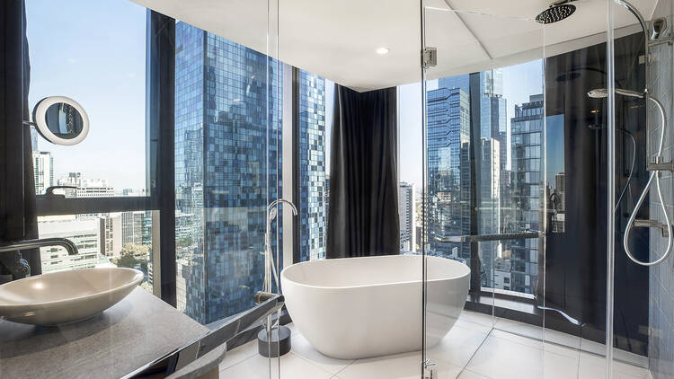 A bathroom with a deep bath with views on two sides
