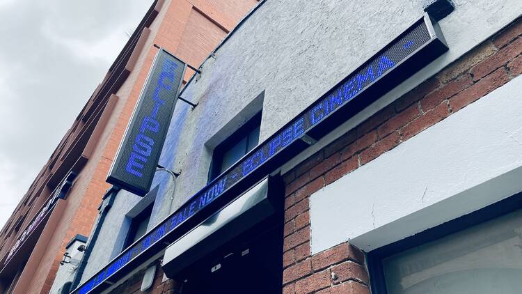 The exterior blue neon sign for Eclipse Cinema.