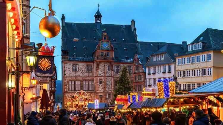  Old market place with the christmas decoration, old houses with stores, restaurants and visitors of the christmas market. Traditional Christmas market.