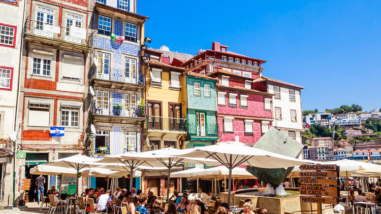 People dining al fresco in Porto, Portugal, with colourful buildings in the background