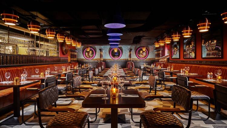 Bartley’s Restaurant at the Grafton Hotel in Dublin: low ceilinged atmospherically-lit room with dark wooden tables, leather chairs and tiled floor 