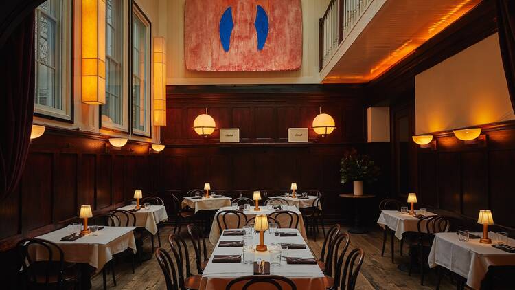Interior of F&F Restaurant and Bar with dark wood and white tablecloths