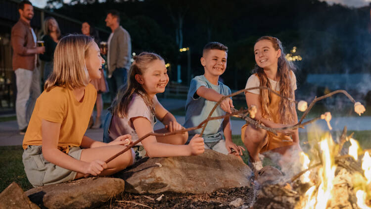 Kids roasting marshmallows at a campfire