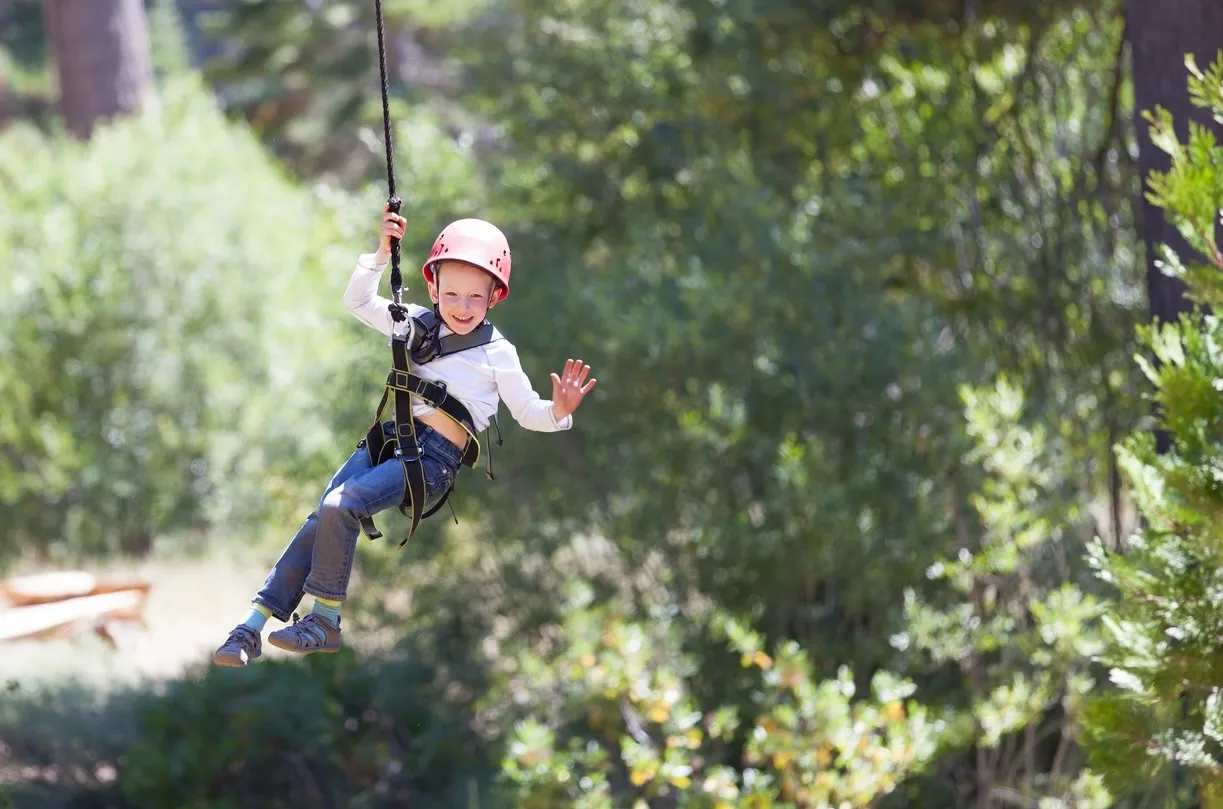 brave little boy ziplining in adventure park