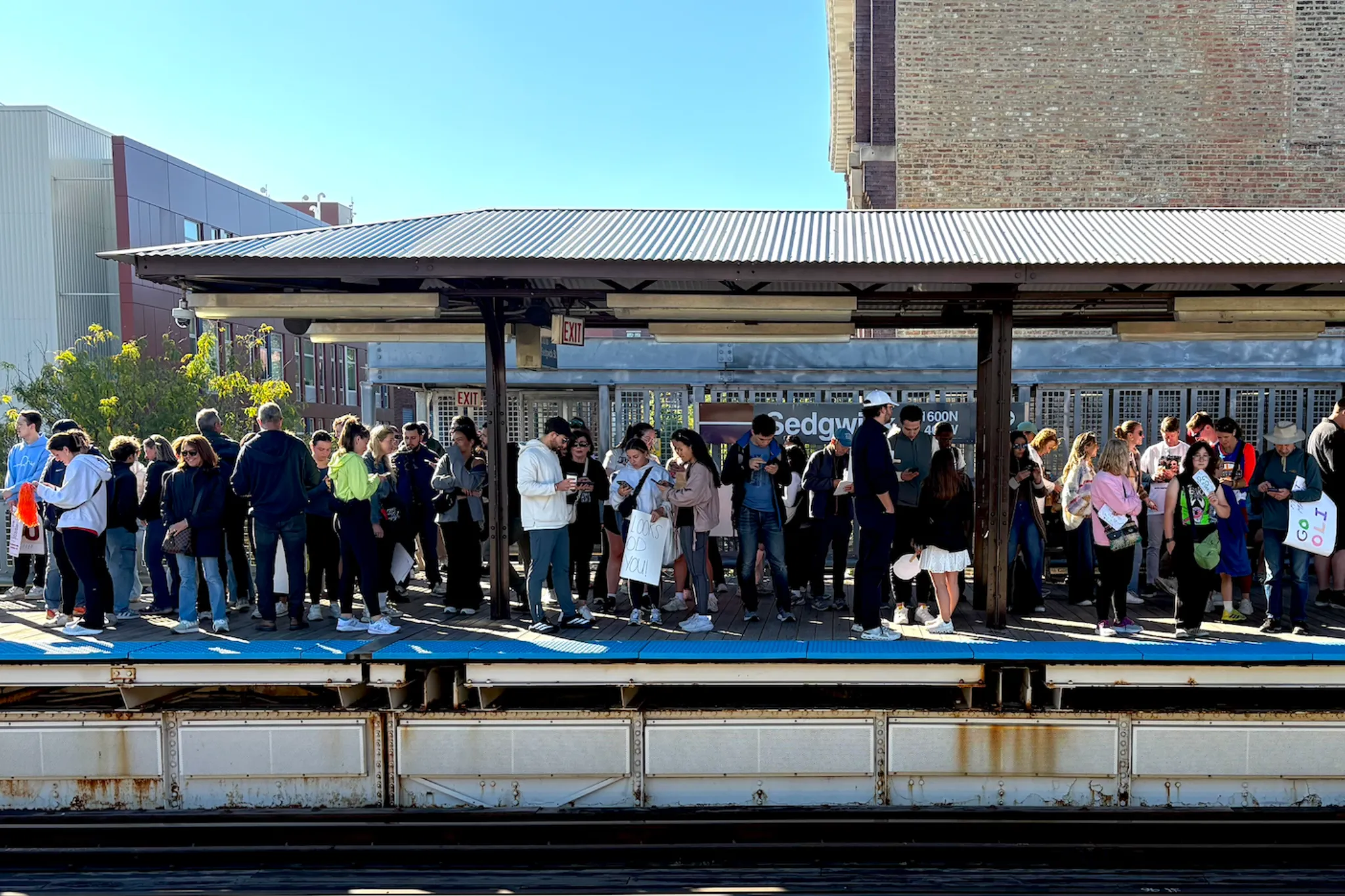 Chicago Marathon 2025 attendees wait at the Sedgwick Brown Line stop.