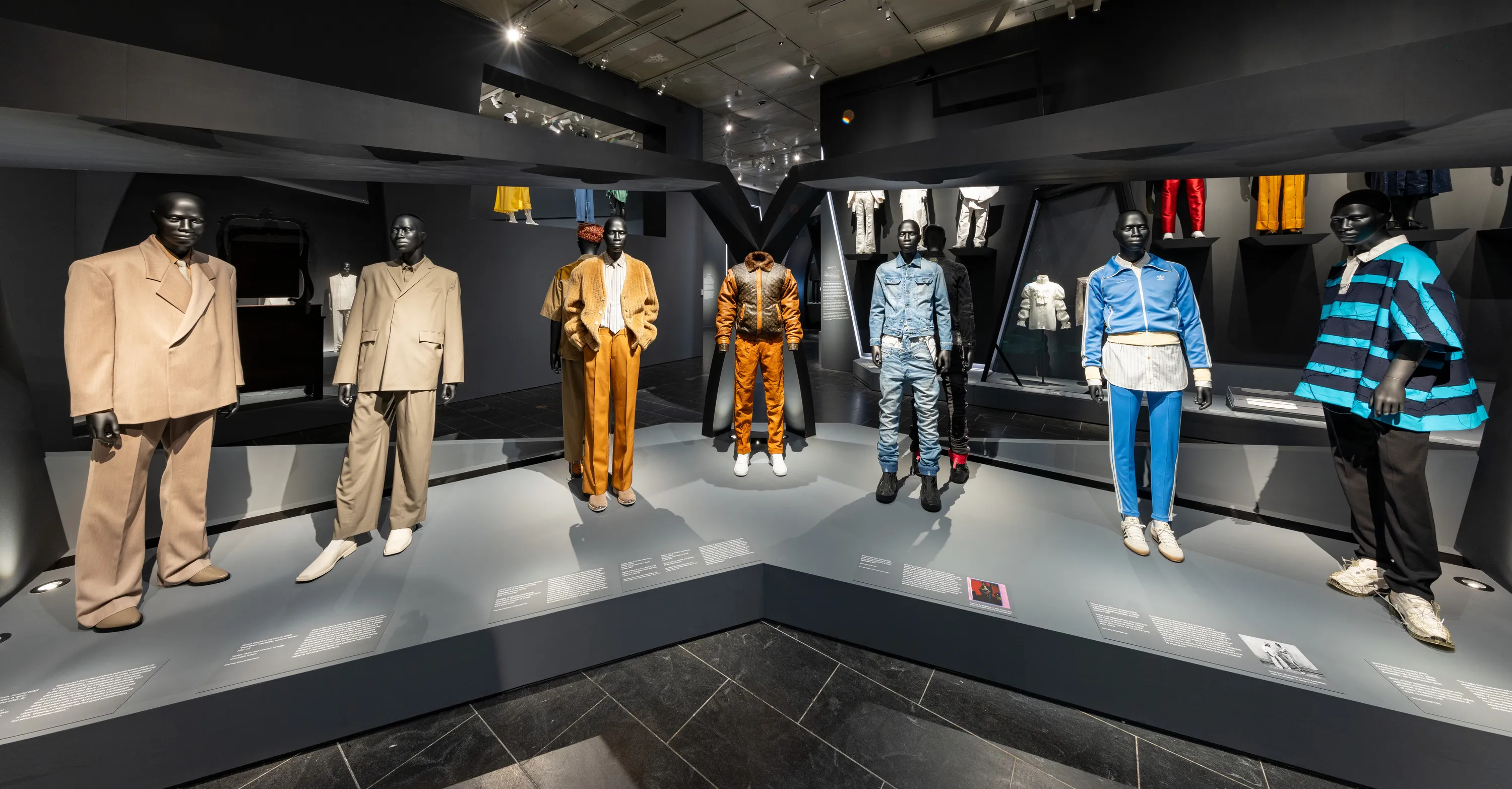 Seven mannequins display a variety of menswear outfits.