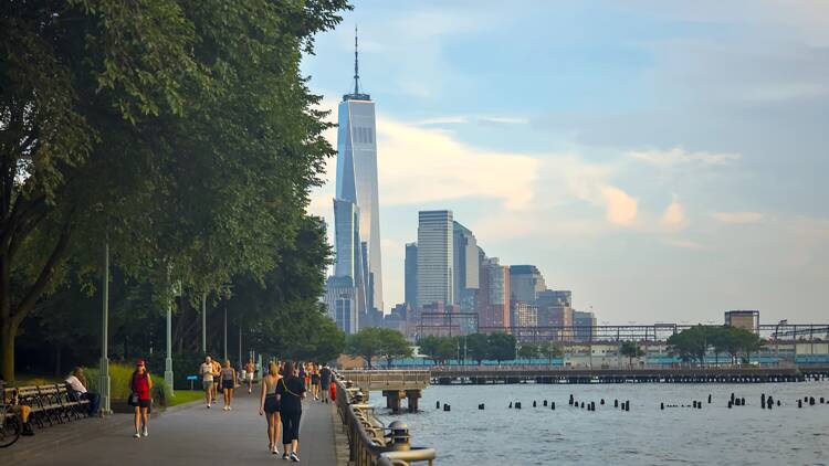 People walking on the West Side Highway greenway next to the Hudson River