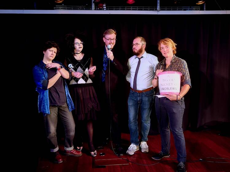 Comedians holding a bucket n the English language stand up club in Helsinki
