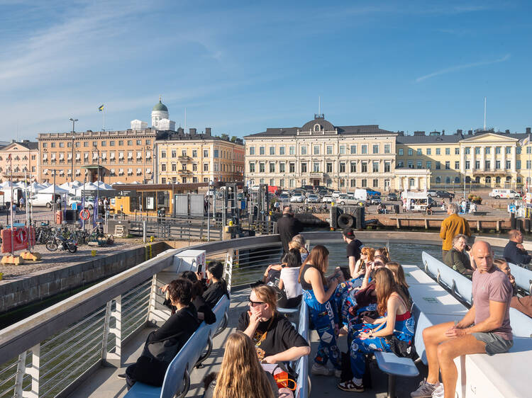 People sitting at the Suomenlinna ferry in front of Market Square in Helsinki People sitting at the Suomenlinna ferry in front of Market Square in Helsinki
