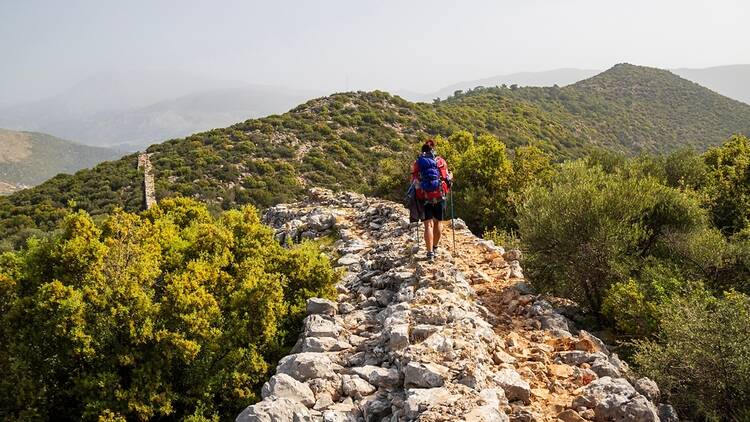 A person hiking along ancient stones on the Lycian Way in Türkiye