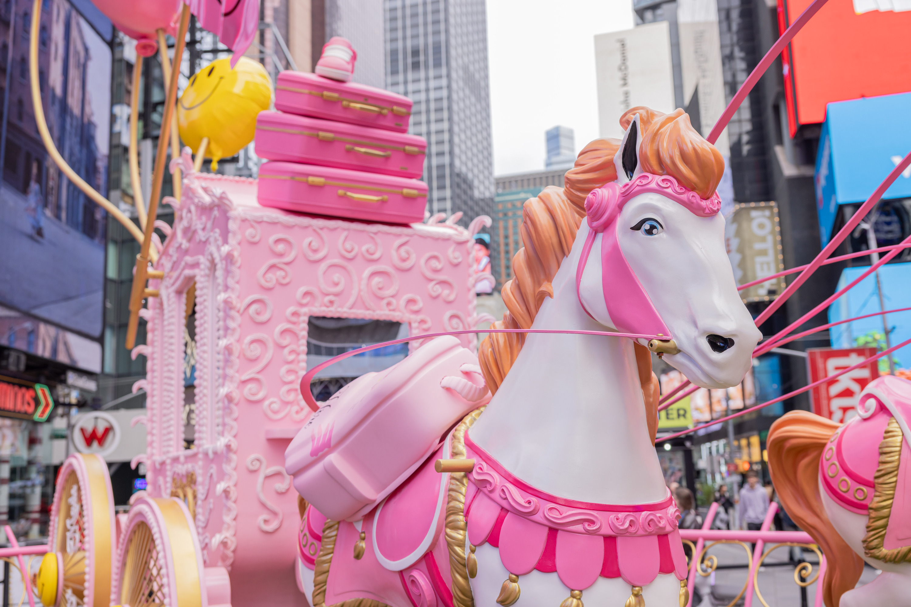A close-up of a white-and-pink plastic carriage horse.