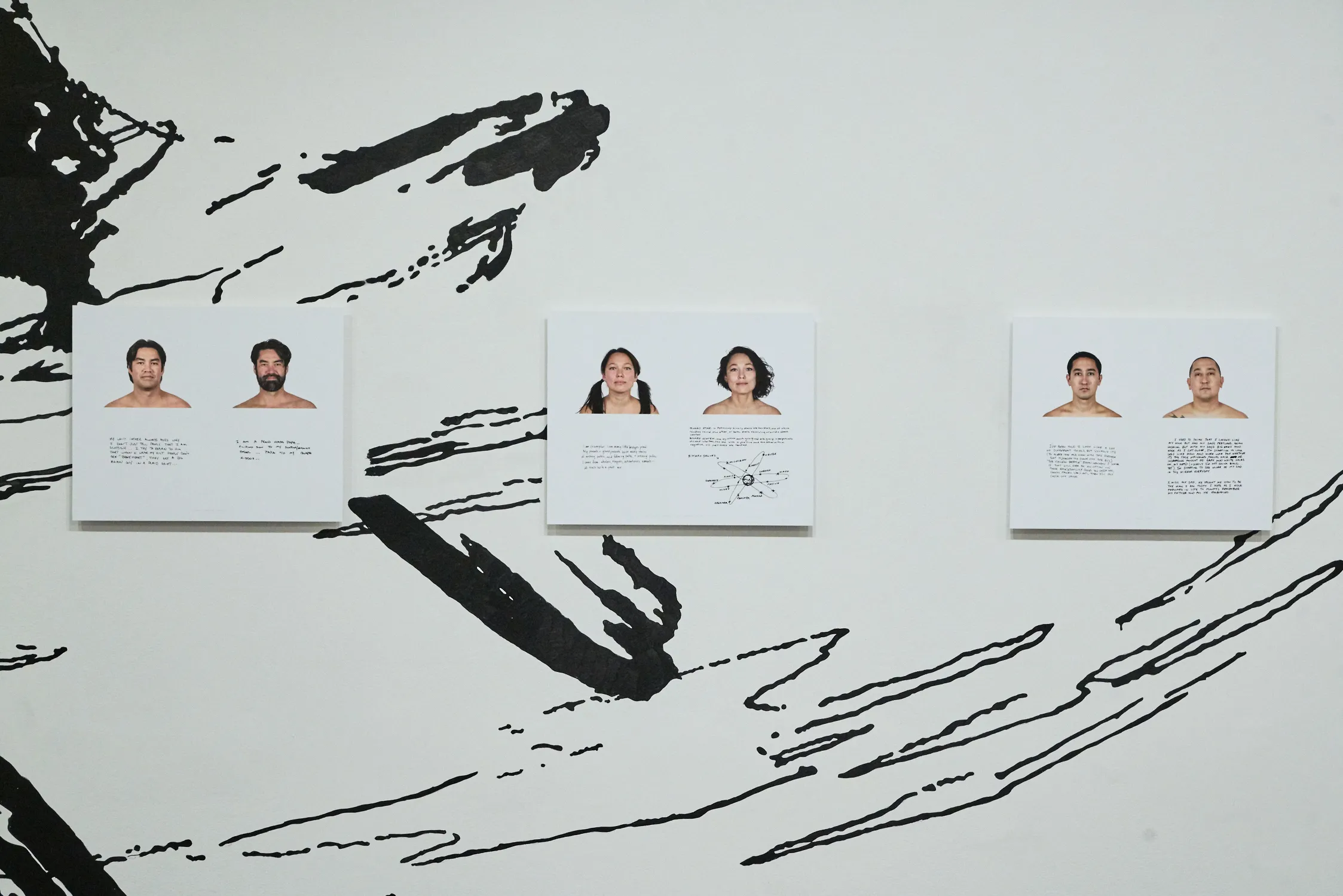 Photo of a photography show on dispay, showing three of the exhibit's photos of people photographed