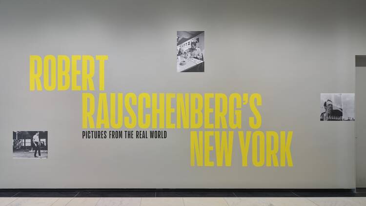 a photo of a wall in an exhibition with the title written in yellow blockhead: "Robert Rauschenberg’s New York" a photo of a wall in an exhibition with the title written in yellow blockhead: "Robert Rauschenberg’s New York"