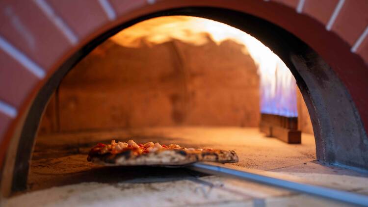 Pizza going into an oven at The Woodstock Hotel