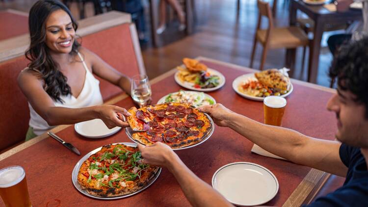 People eating pizza at The Woodstock Hotel