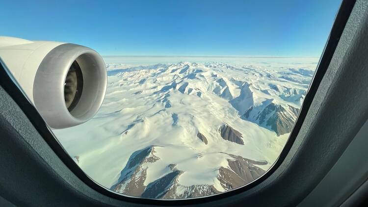View of icy mountains outside airplane
