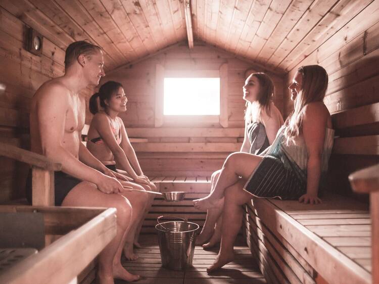 Traditional Finnish sauna experience at Suolijärvi Sauna in Tampere with people relaxing and socializing on wooden benches. Traditional Finnish sauna experience at Suolijärvi Sauna in Tampere with people relaxing and socializing on wooden benches.