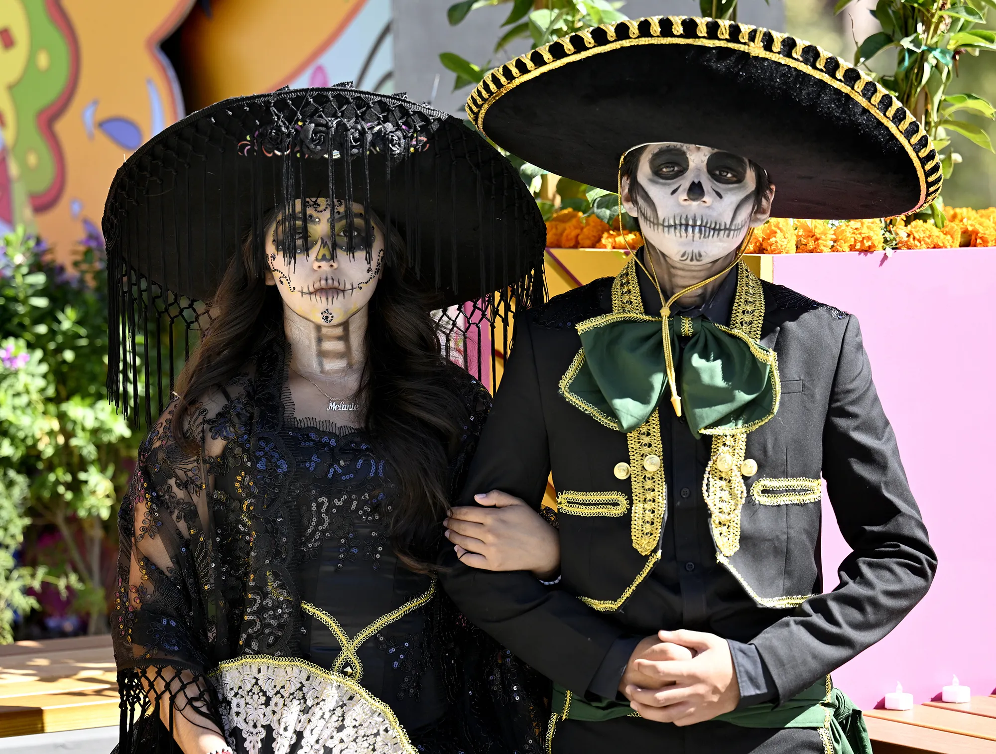 A girl and boy with faces painted to look like skeletons.