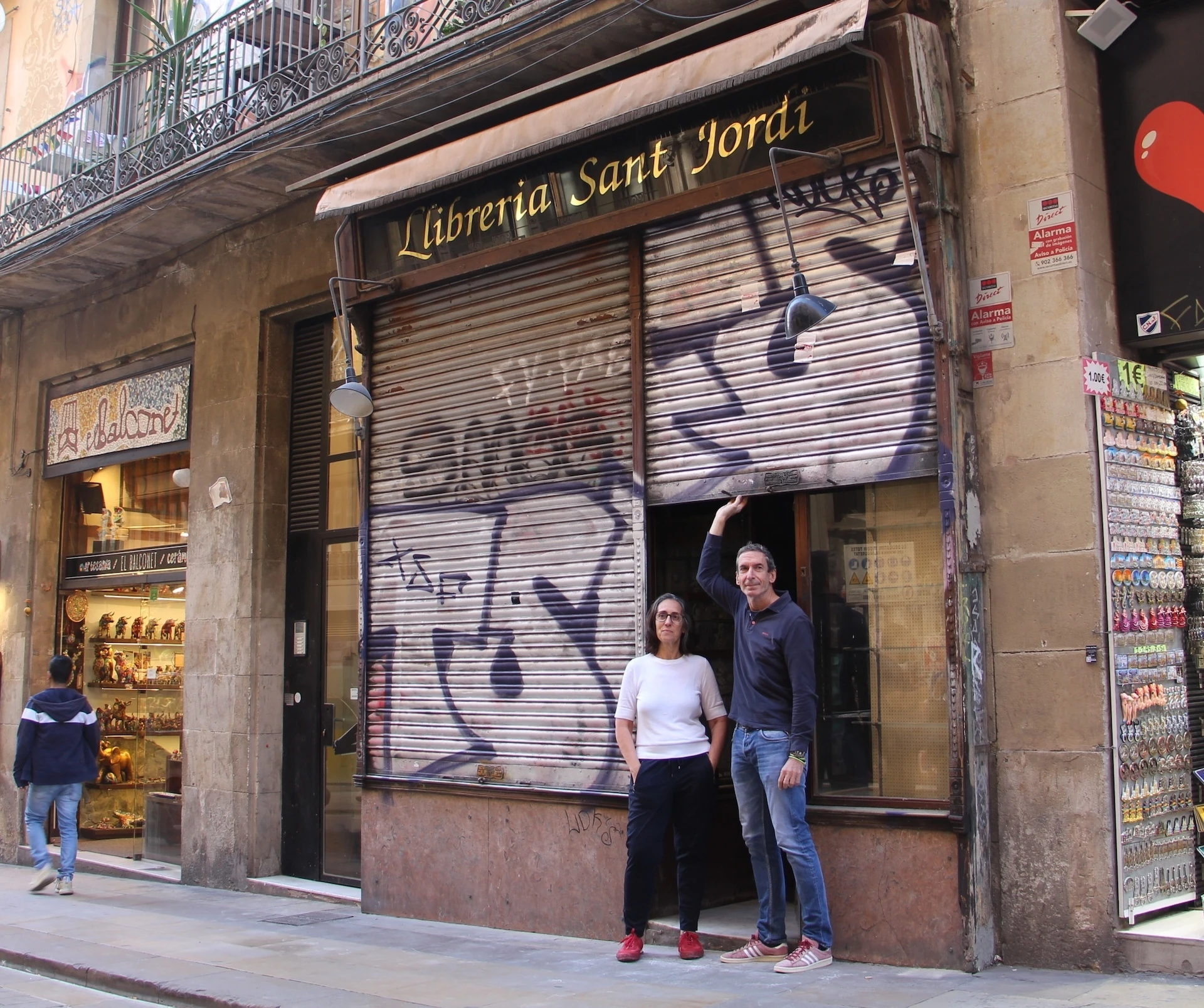 La Judit Gim&eacute;ne i en Rafa Serra aixequen la persiana de la futura llibreria Sant Jordi