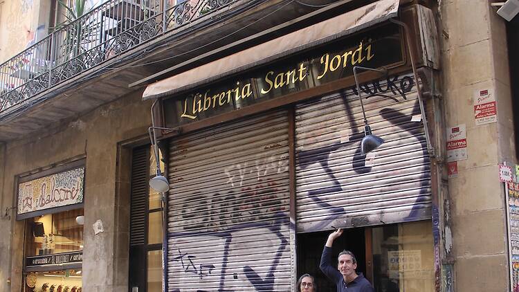 La Judit Giménez i en Rafa Serra aixequen la persiana de la Llibreria Sant Jordi