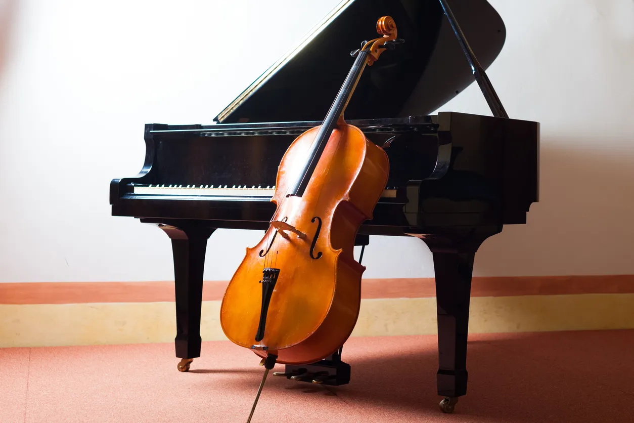 Violin leaning on a piano