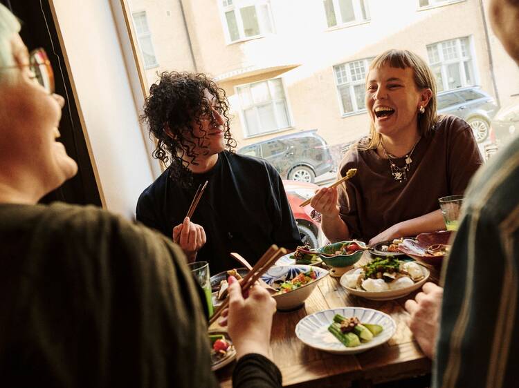 Ystäväporukka nauttii aasialaista ruokaa helsinkiläisessä ravintolassa ikkunapöydässä. Ystäväporukka nauttii aasialaista ruokaa helsinkiläisessä ravintolassa ikkunapöydässä.