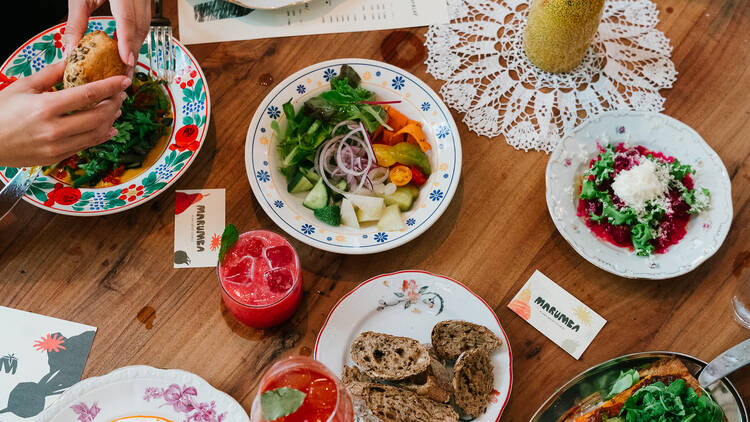 Marumba étterem Marumba étterem ételei az asztalon, mint kovászos kenyér, rakott krumpli, kombucha, vizikefir, kenyérlángos, vegán sült zsír, fermentált zöldségek