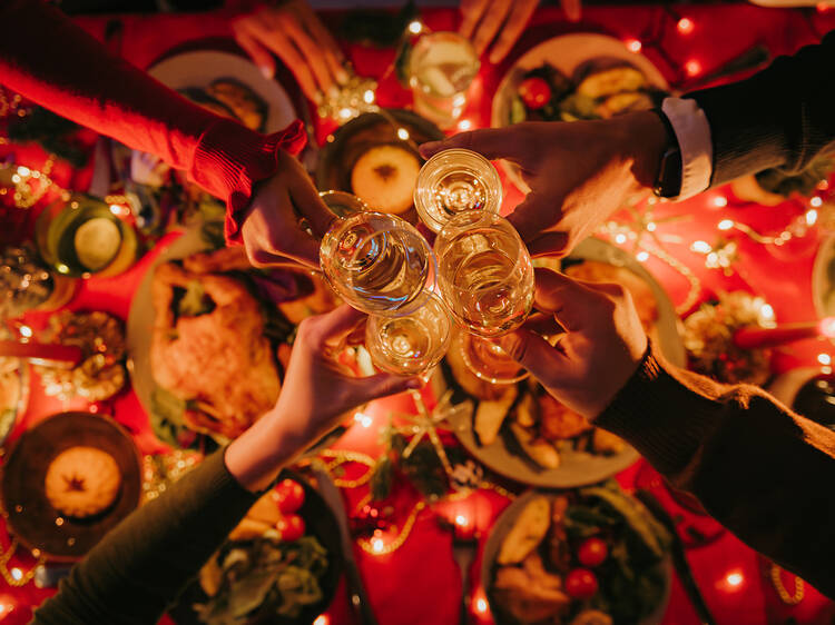 Top view of people toasting with champagne while enjoying New Year Eve at the decorated holiday table 1818488912