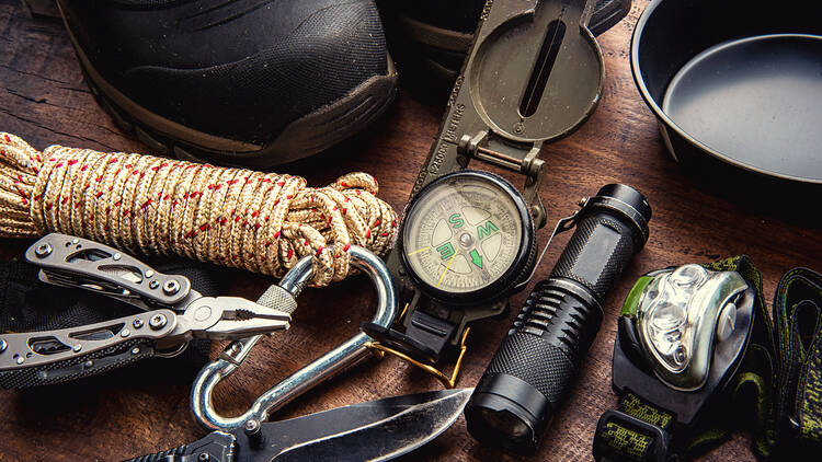 Outdoor travel equipment planning for a mountain trekking camping trip on wooden background Outdoor travel equipment planning for a mountain trekking camping trip on wooden background. Top view - vintage film grain filter effect styles