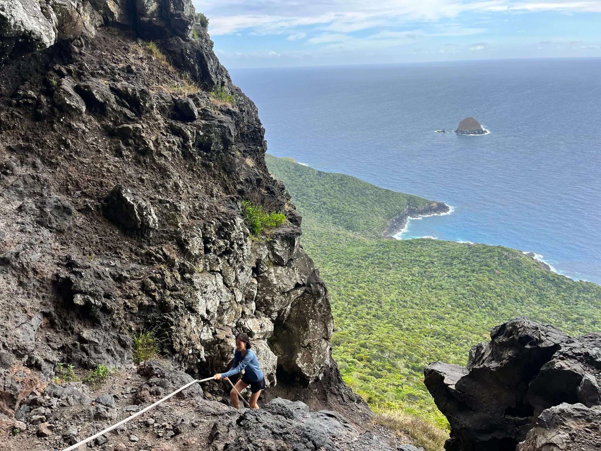 Girl hiking mountain near ocean
