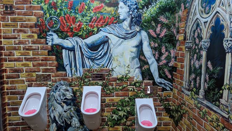 Urinals under mural