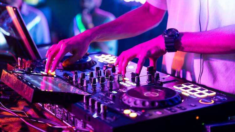 Stock image of DJ on the decks in a nightclub