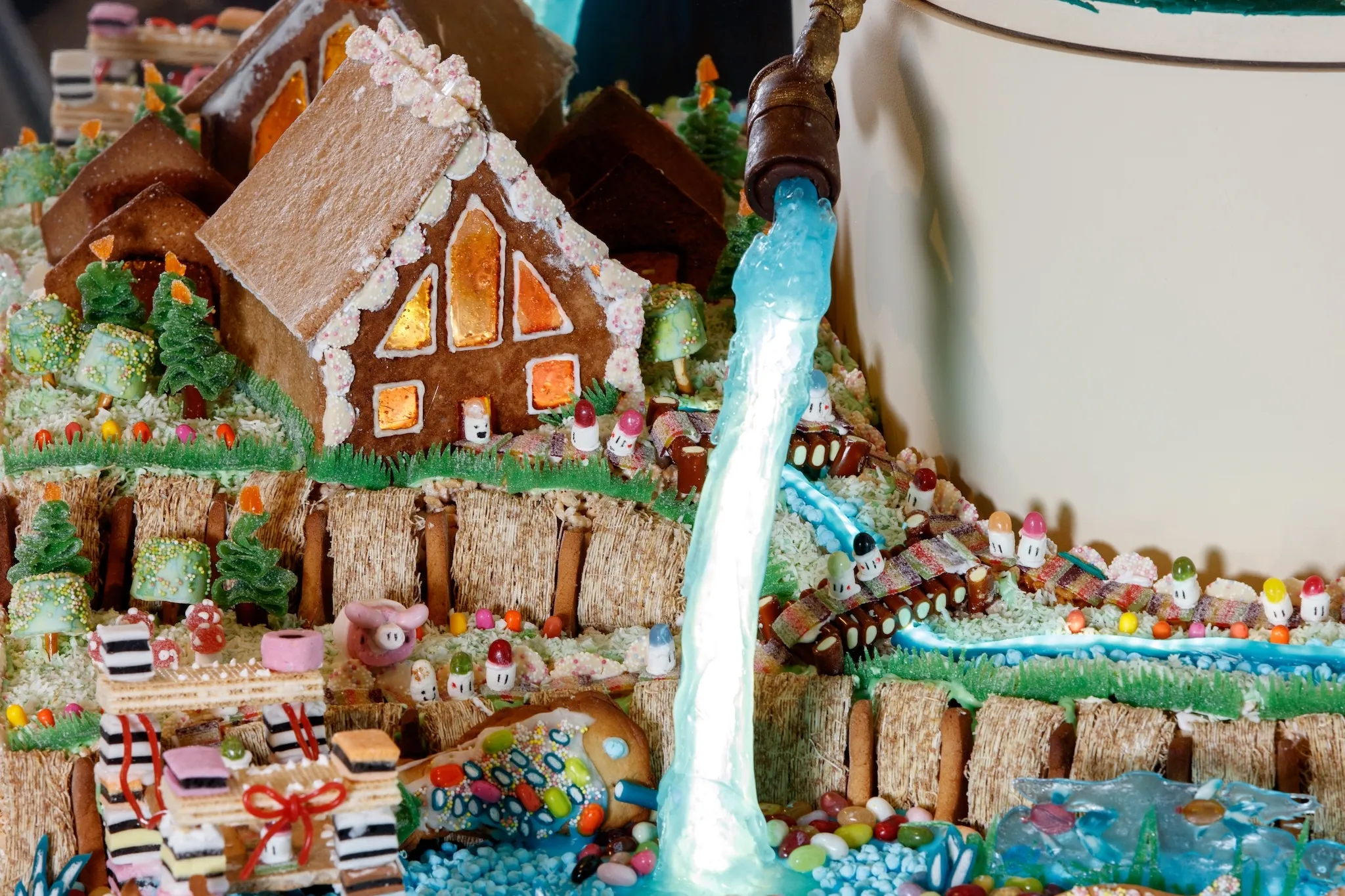 A gingerbread city with a frozen waterfall running through it