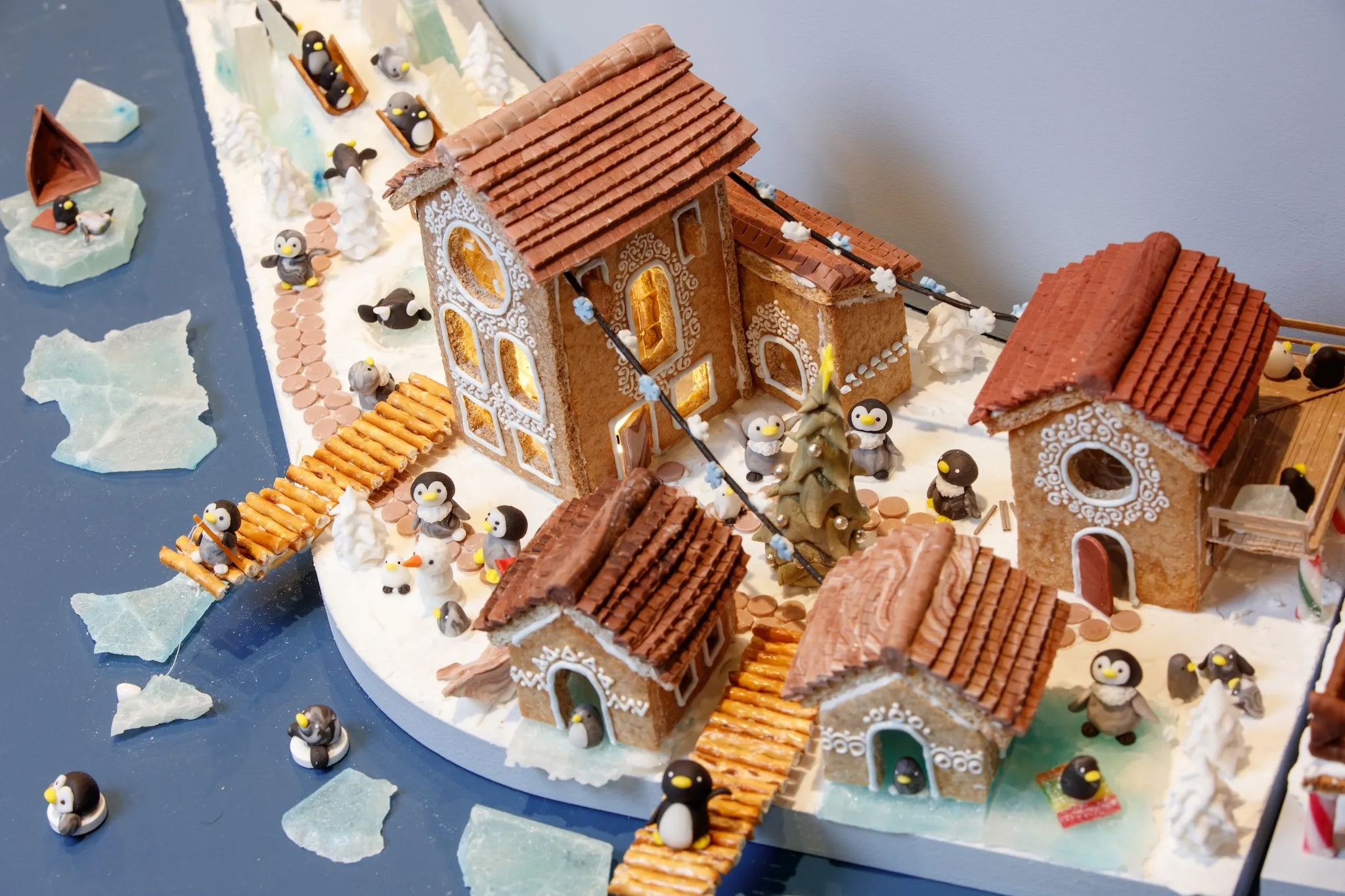 gingerbread houses and bridges with mini penguins surrounding it