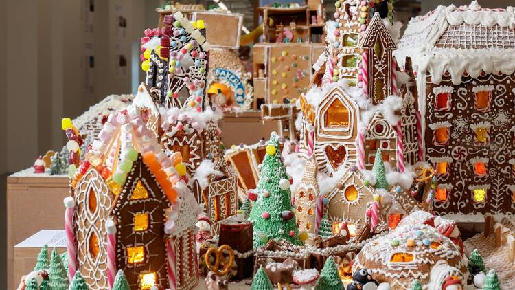 Several gingerbread houses decorated and lit up in a holiday landscape Several gingerbread houses decorated and lit up in a holiday landscape