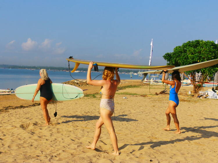 Women walking with surfboards