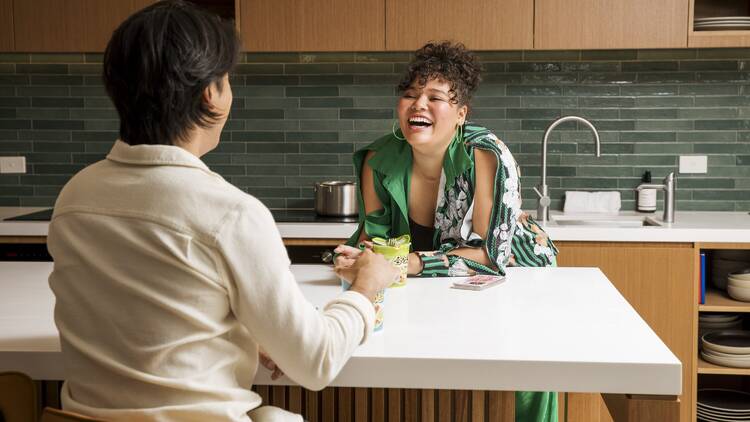 A woman and man laughing in a kitchen