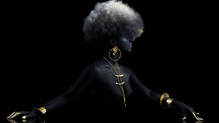 A woman wears golden jewelry.