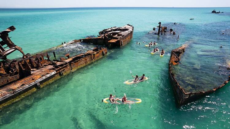 An aerial image of people kayaking near the shipwrecks