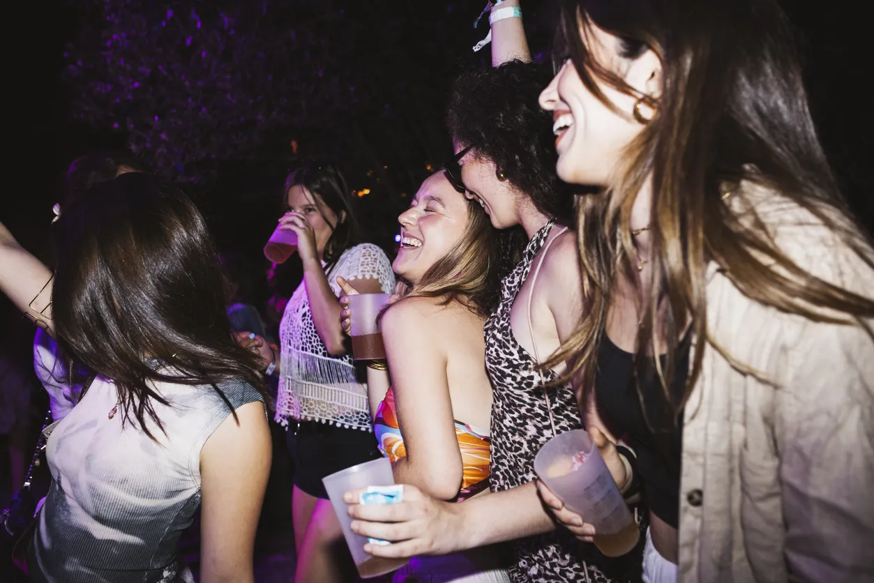 Group of young cheerful women dancing and laughing in a night club.