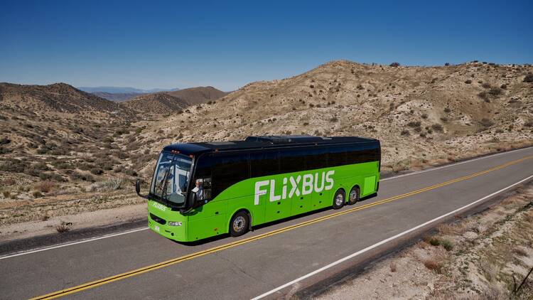FlixBus Green bus driving near mountains