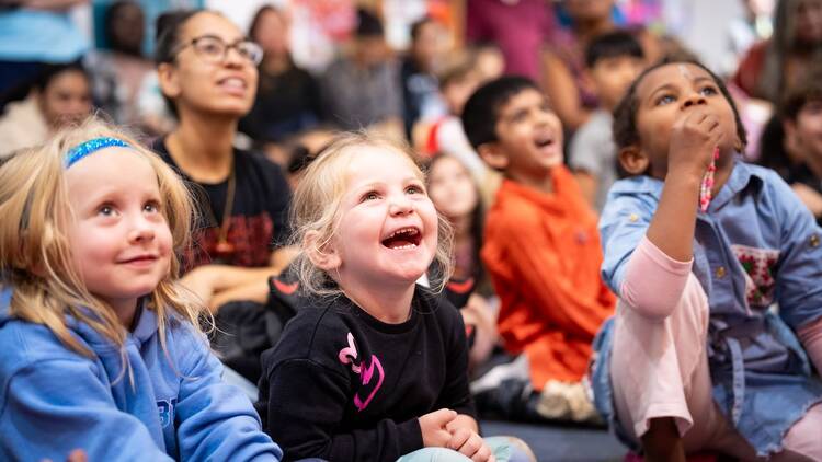A group of kids watching a live performance at the children's museum of manhattan