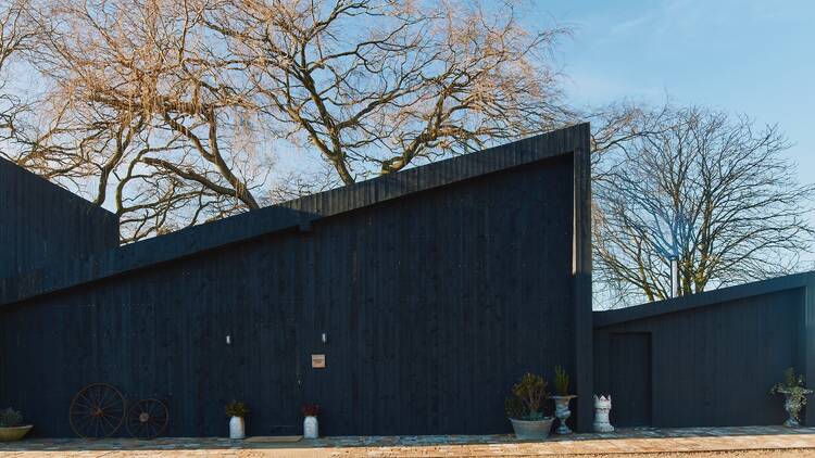 Bonington Farm exterior showing a black triangular cabin building Bonington Farm exterior showing a black triangular cabin building