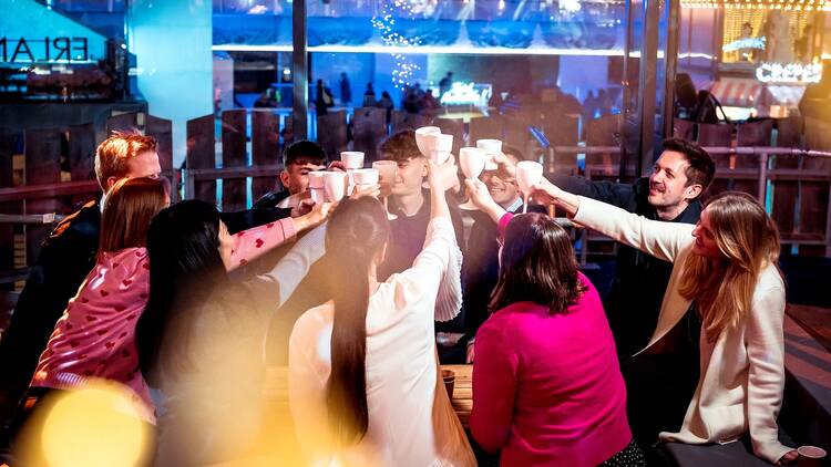 The Winter Club Canary Wharf A group of colleagues standing in a circle raise a toast at The Winter Club Canary Wharf